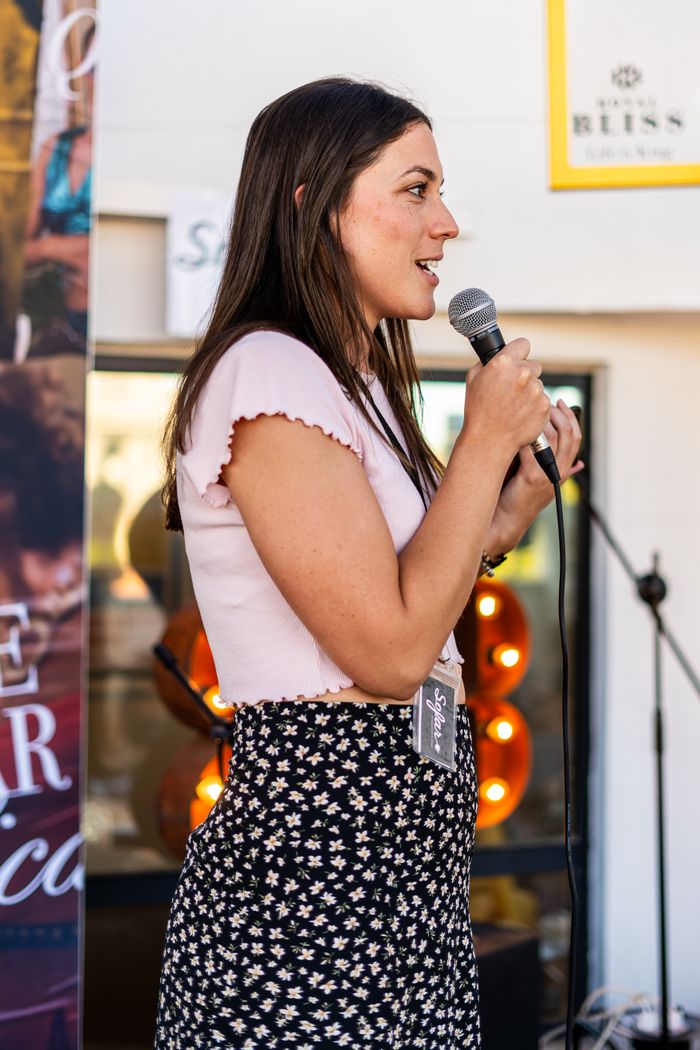Outdoor candid shot of a female speaker passionately addressing an audience.